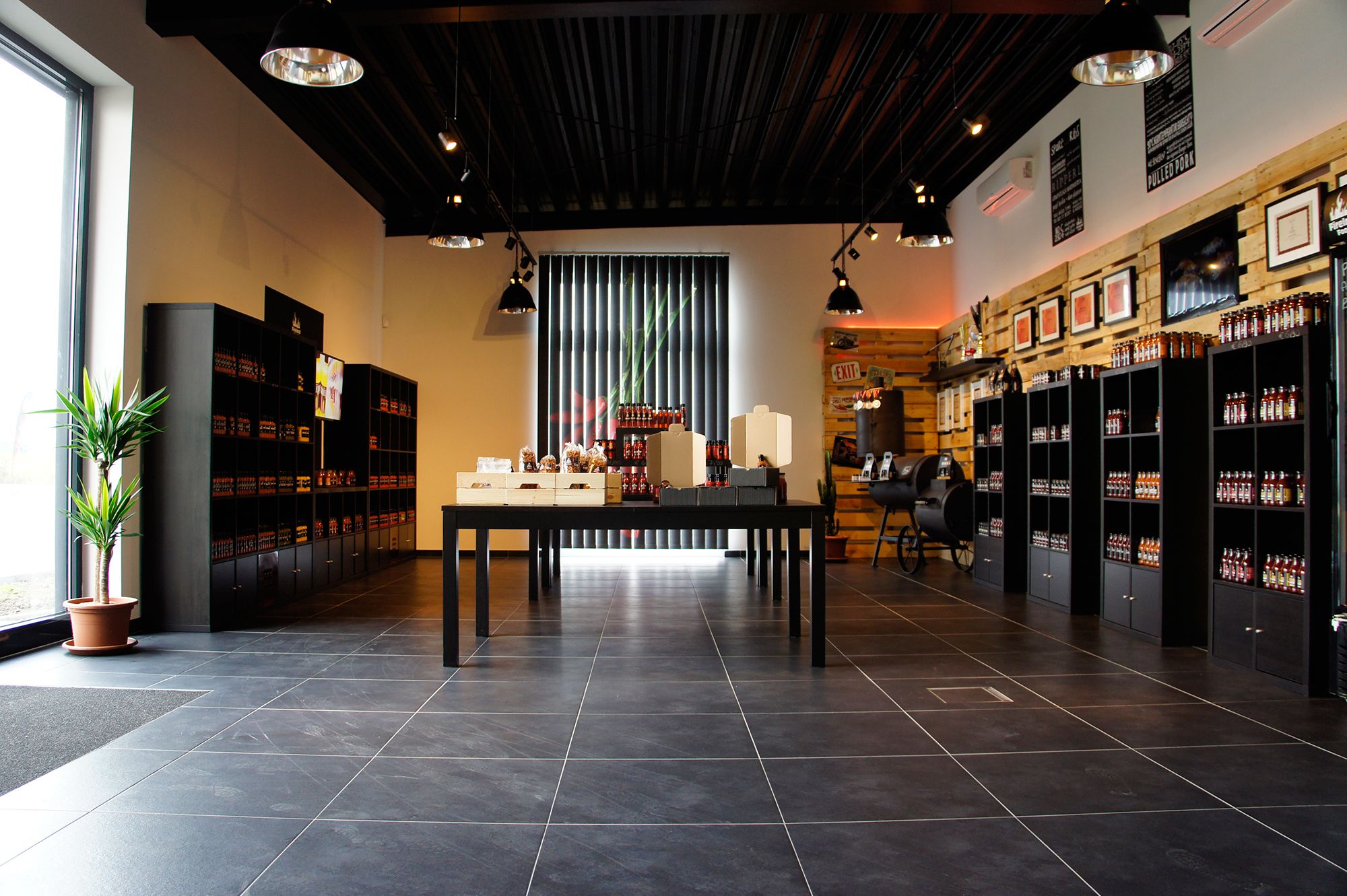 Innenansicht eines modernen Ladens mit Regalen voller Produkte und einem Tisch in der Mitte.