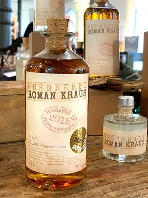 Flaschen von Brennerei Roman Kraus auf einem Holztisch.