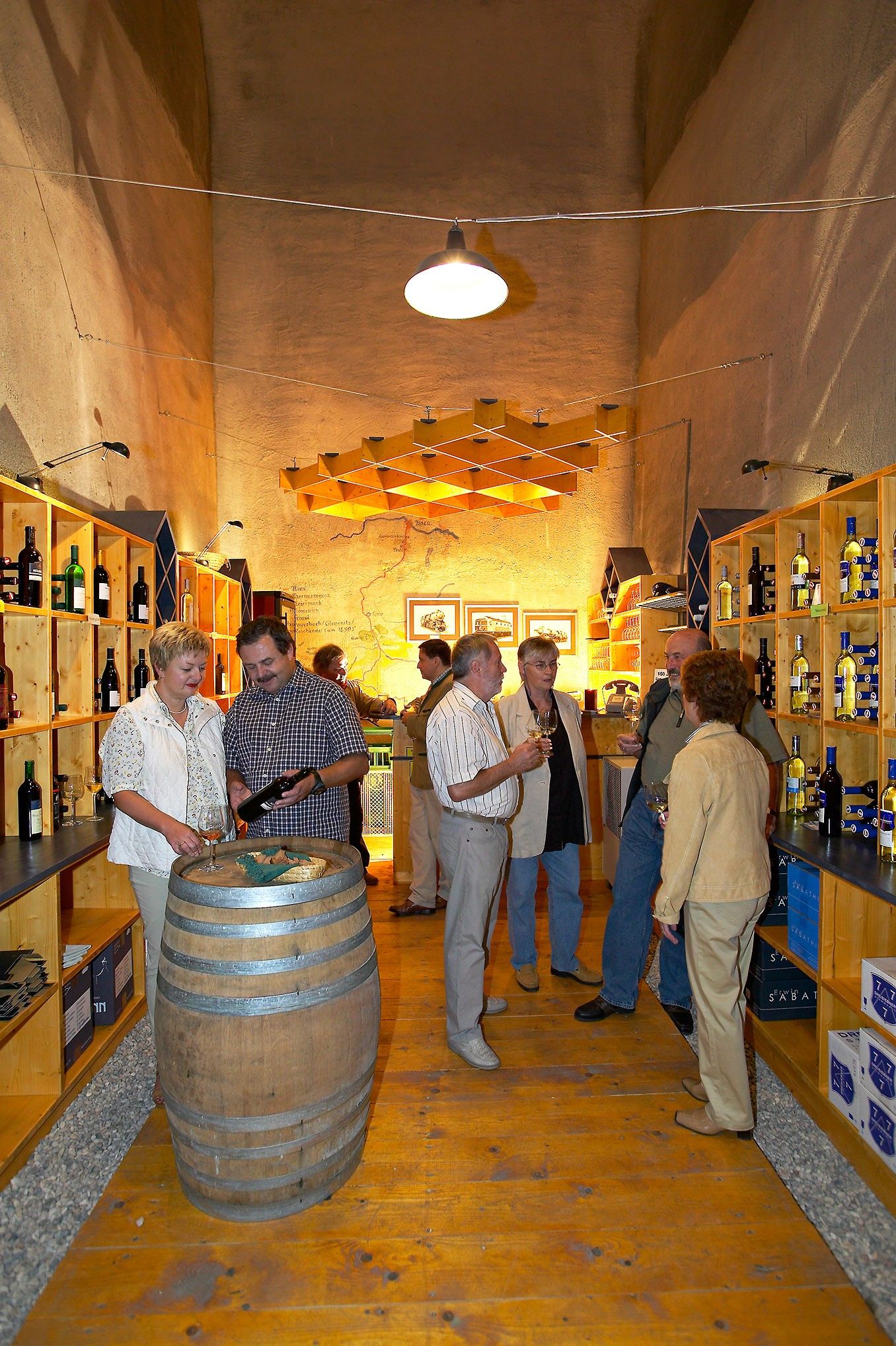 Menschen in einem Weinkeller bei einer Weinprobe.