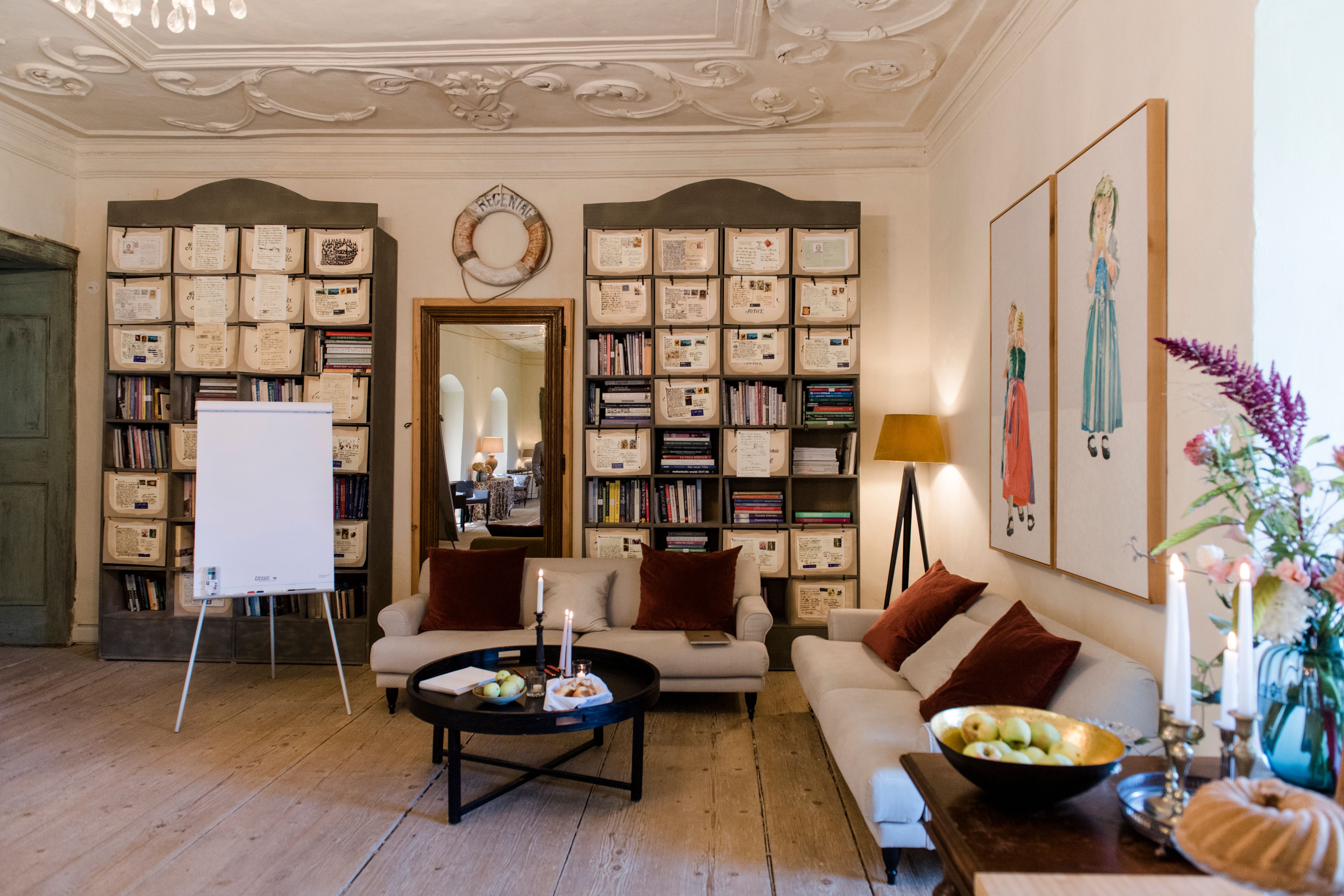 Gemütlicher Raum mit Sofas, Bücherregalen und Dekorationen.