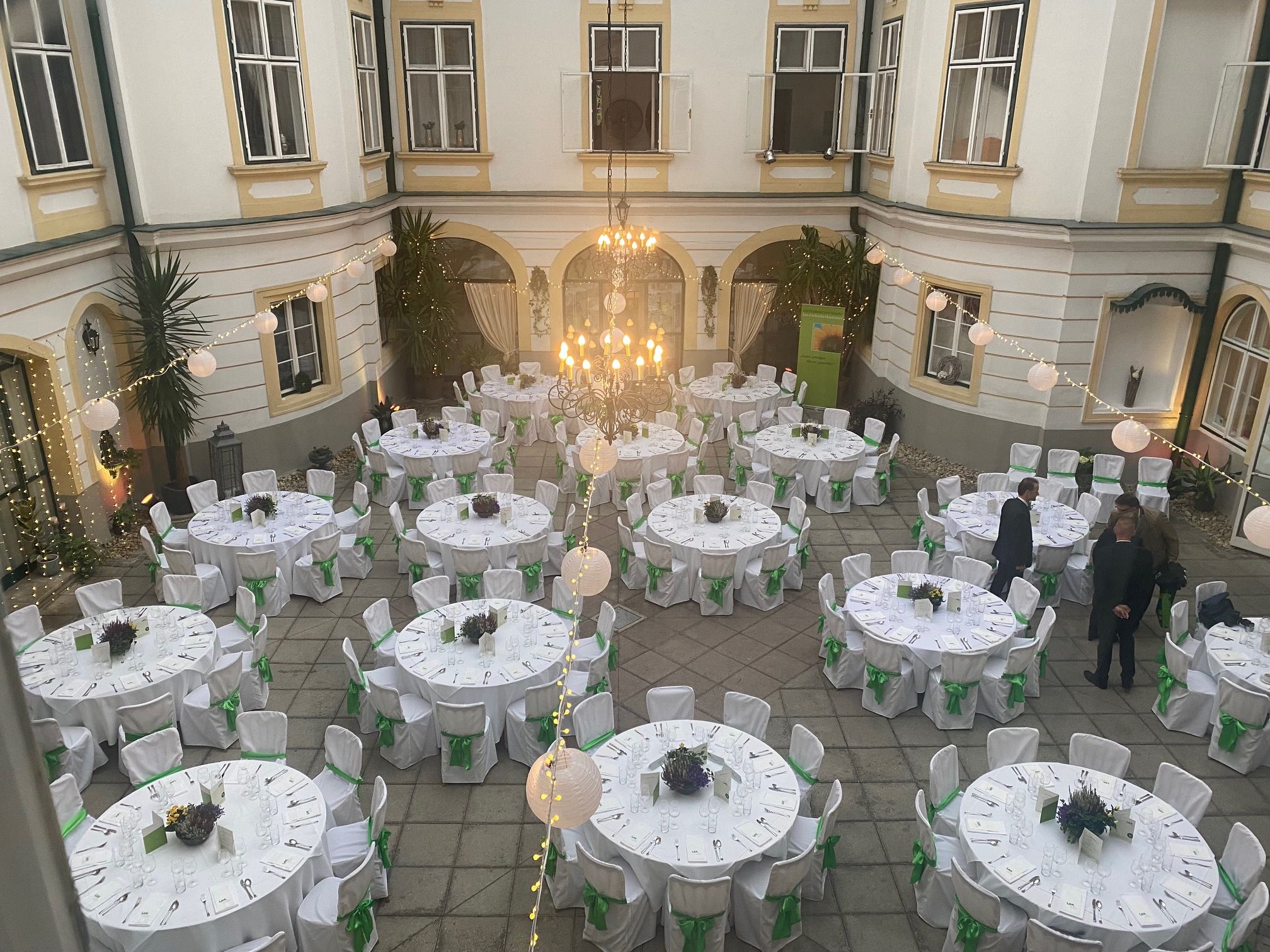 Innenhof mit runden weiß gedeckten Tischen und Sesseln