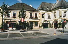 Historische Gebäude mit Geschäften und dekorativen Fassaden an einem sonnigen Tag.