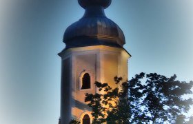Beleuchteter Kirchturm der Pfarrkirche Sallingberg bei Dämmerung.