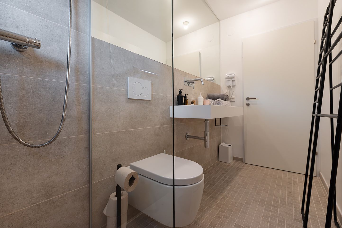 Modernes Badezimmer mit Glasdusche, Toilette und Waschbecken.