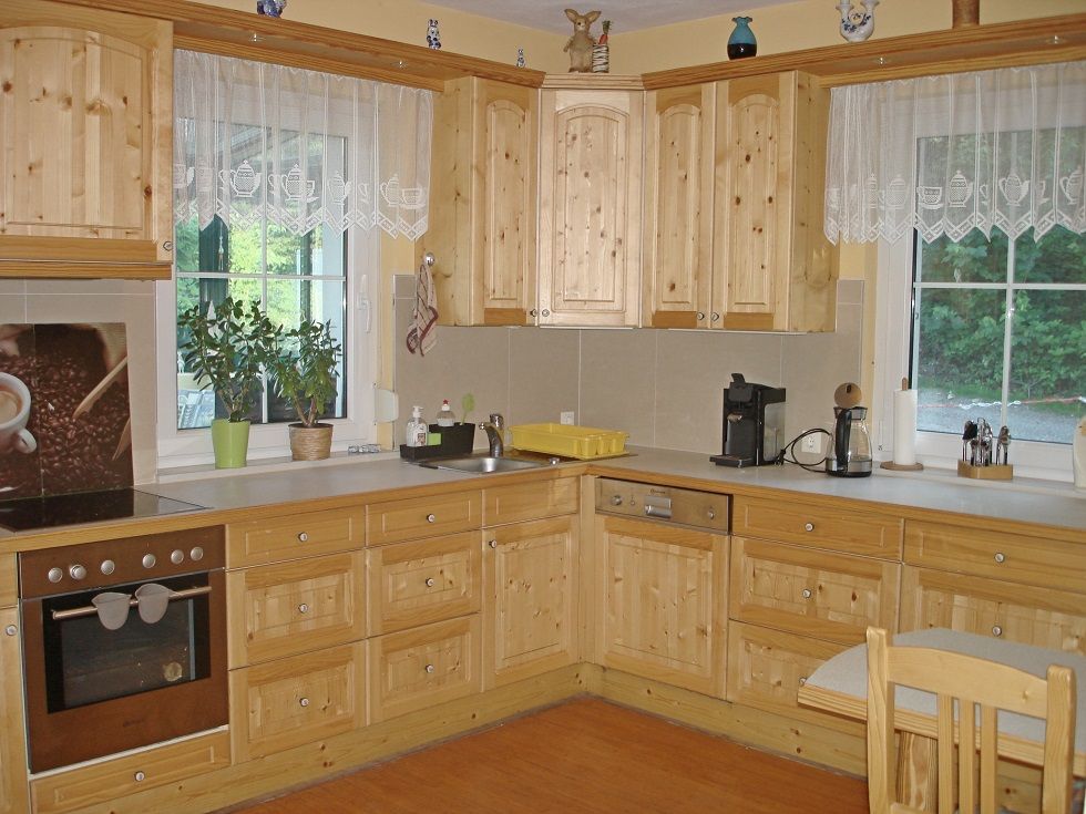 Holzküche mit Geräten und Pflanzen in einem Ferienhaus.