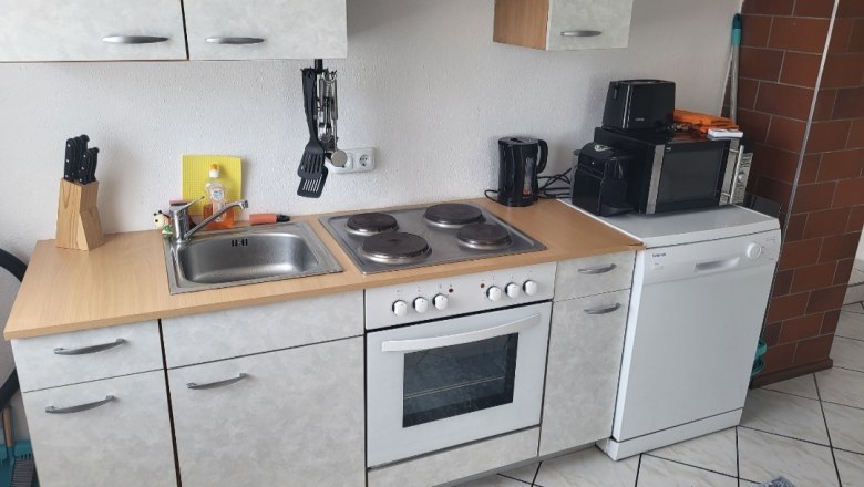 K&uuml;chenzeile mit Herd, Sp&uuml;le, Mikrowelle und Geschirrsp&uuml;ler.