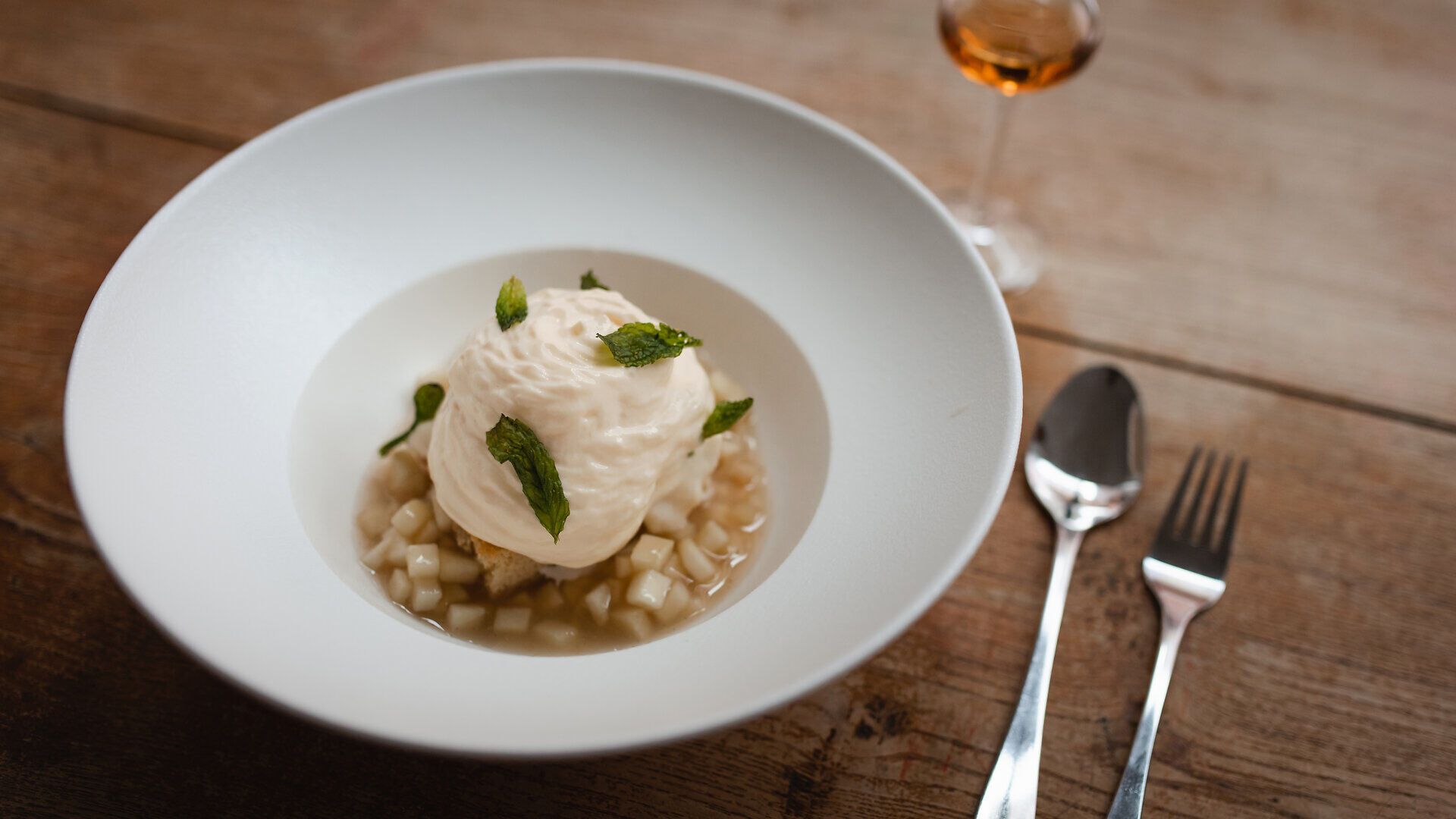 Ein köstliches Dessert, das in einer eleganten Schüssel serviert wird, zieht die Blicke auf sich. Die zarte, luftige Creme wird von frischen Minzblättern gekrönt und harmoniert perfekt mit der fruchtigen Komposition darunter. Ein Genuss, der die Sinne verführt und zum Verweilen einlädt.