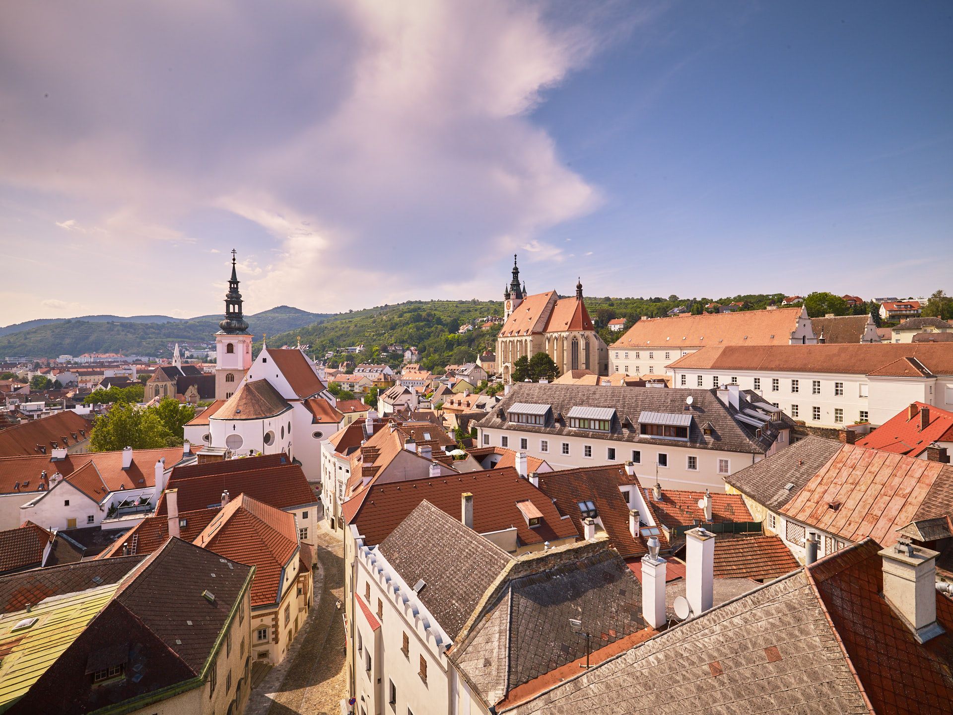 Panoramablick auf die Altstadt von Krems mit Kirchen und roten Dächern.