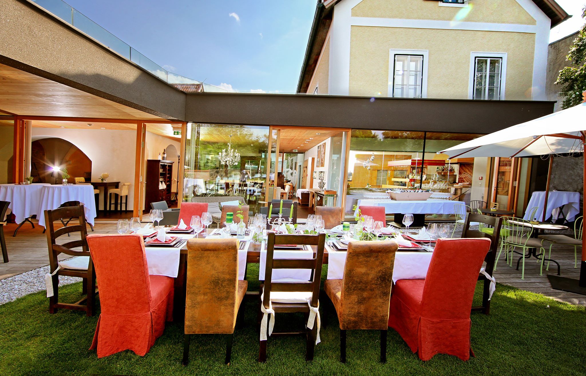 Elegantes Restaurant mit gedecktem Tisch im Freien, umgeben von modernen Gebäuden.