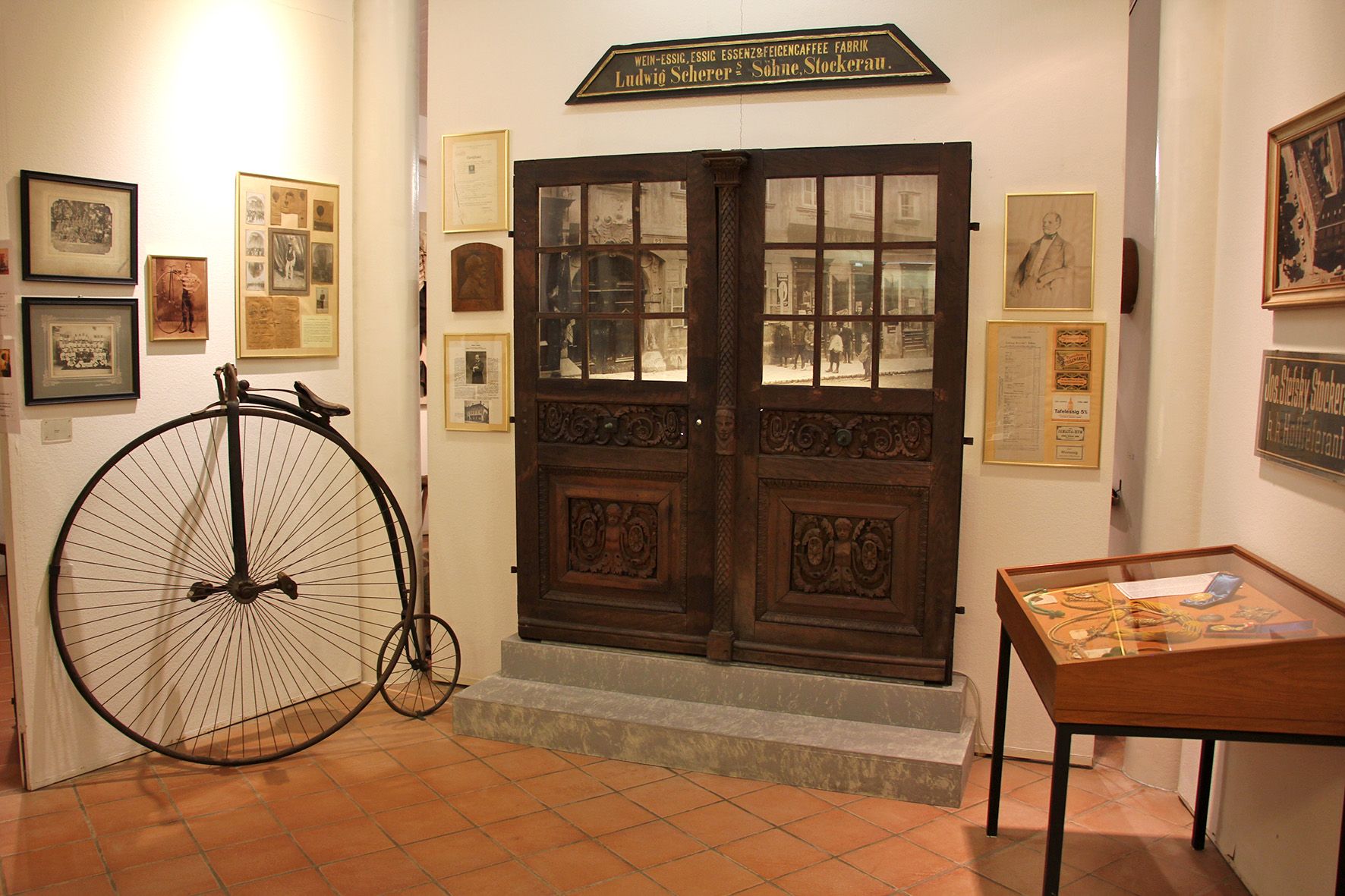 Innenansicht des Bezirksmuseums Stockerau mit Hochrad und historischen Ausstellungsstücken.