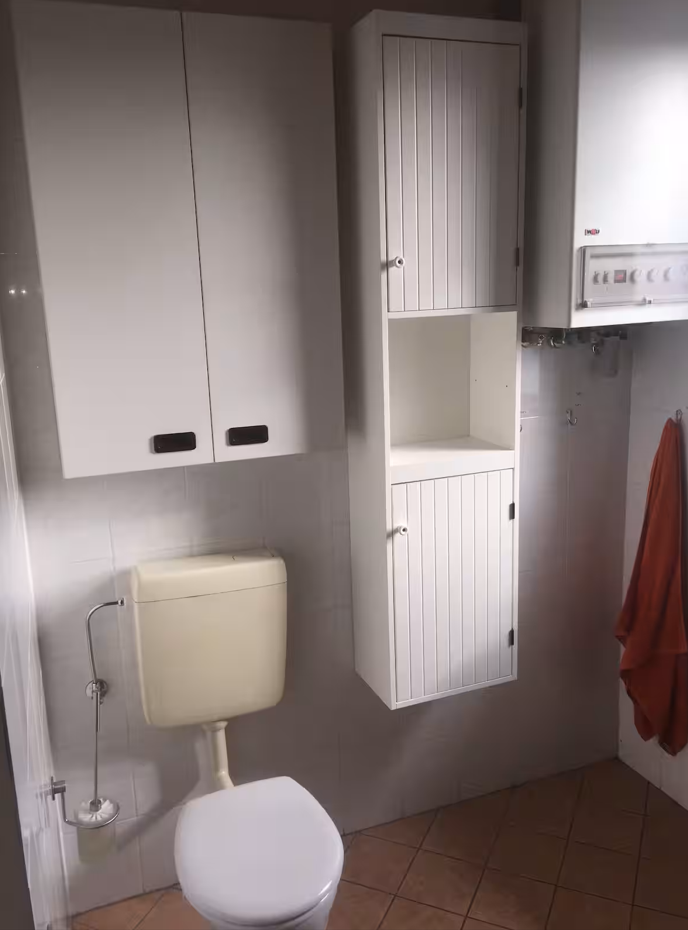 Helles Badezimmer mit WC und Wandregalen