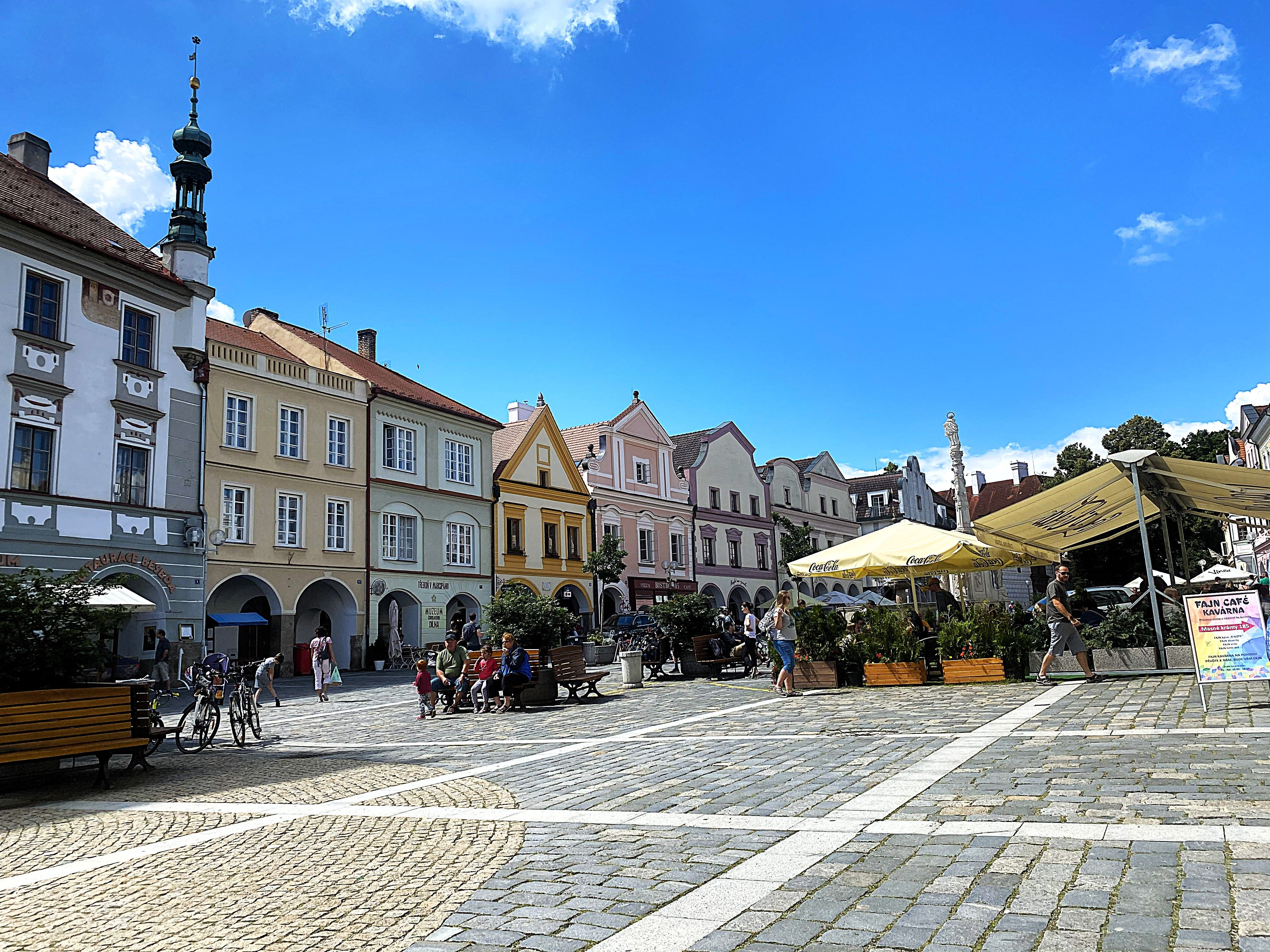 Belebter Stadtplatz mit einer bunten Häuserzeile
