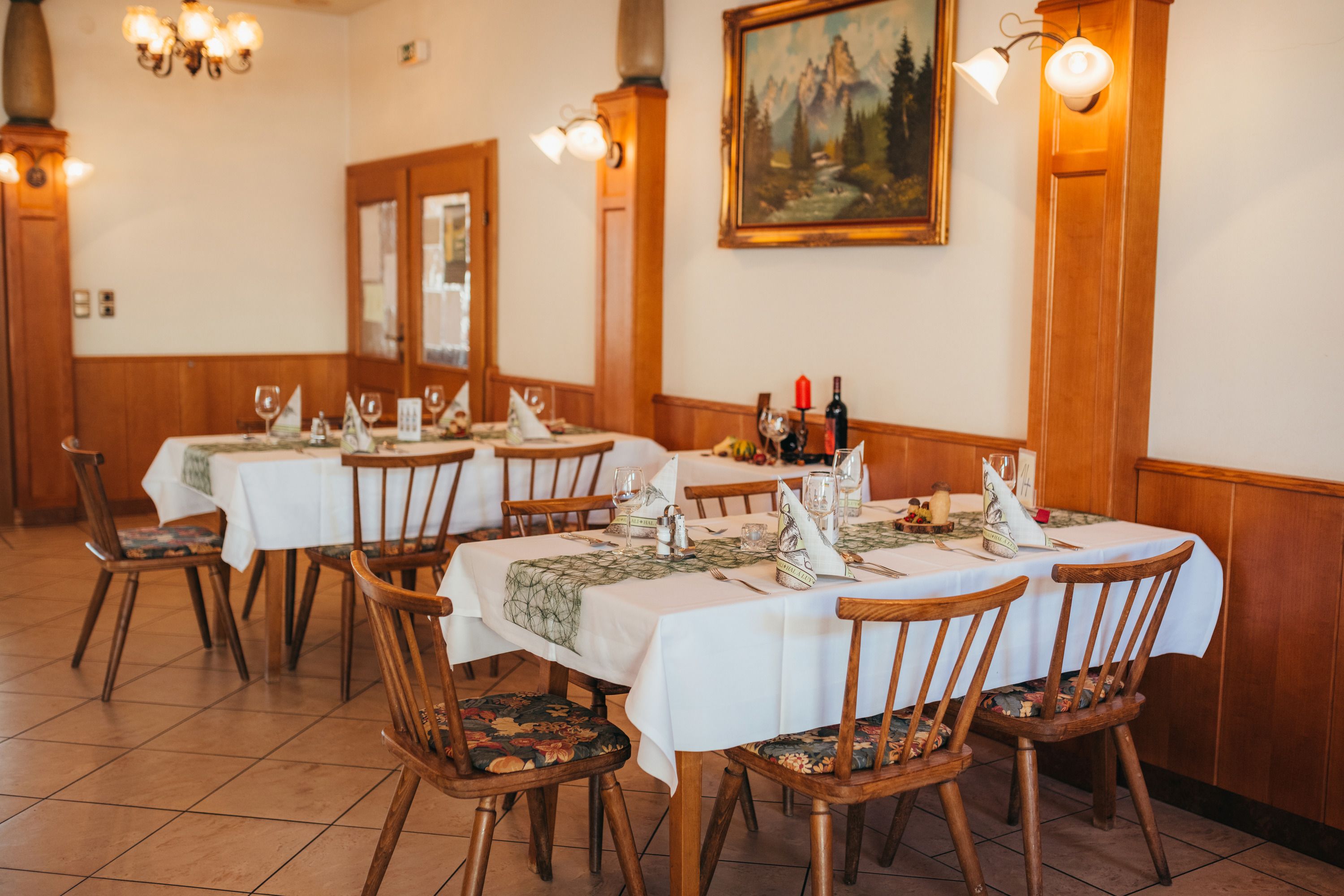 Gemütliches Restaurant mit gedeckten Tischen und rustikaler Einrichtung.