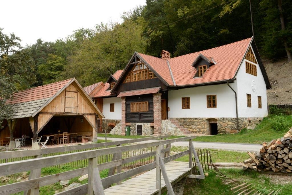 Traditionelles Haus mit rotem Dach und Holzdetails in ländlicher Umgebung.