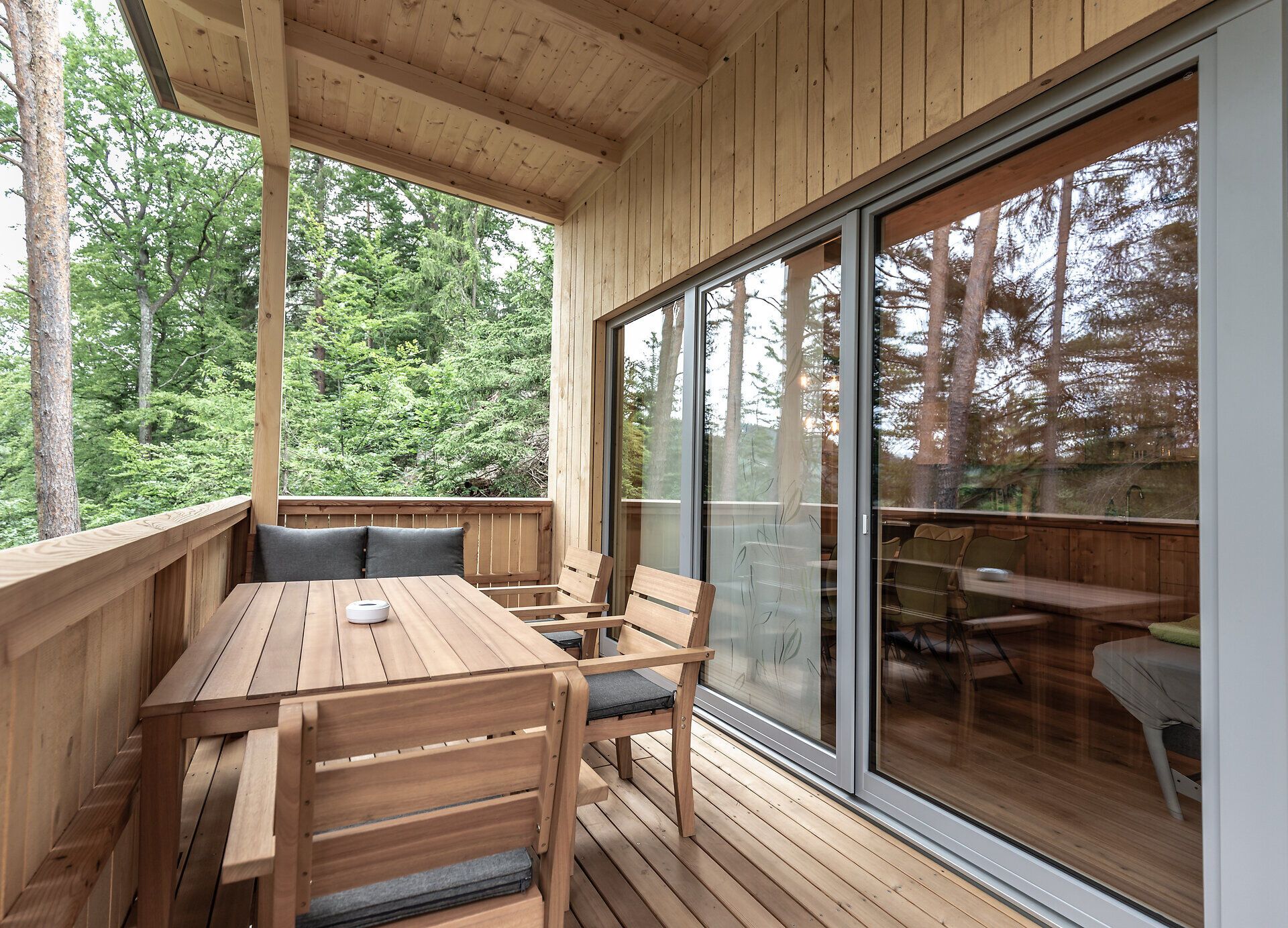 Die einladende Terrasse aus warmem Holz bietet einen perfekten Rückzugsort inmitten der Natur. Umgeben von üppigem Grün und dem sanften Rauschen der Bäume, lädt dieser Ort dazu ein, die Seele baumeln zu lassen und die frische Bergluft zu genießen.