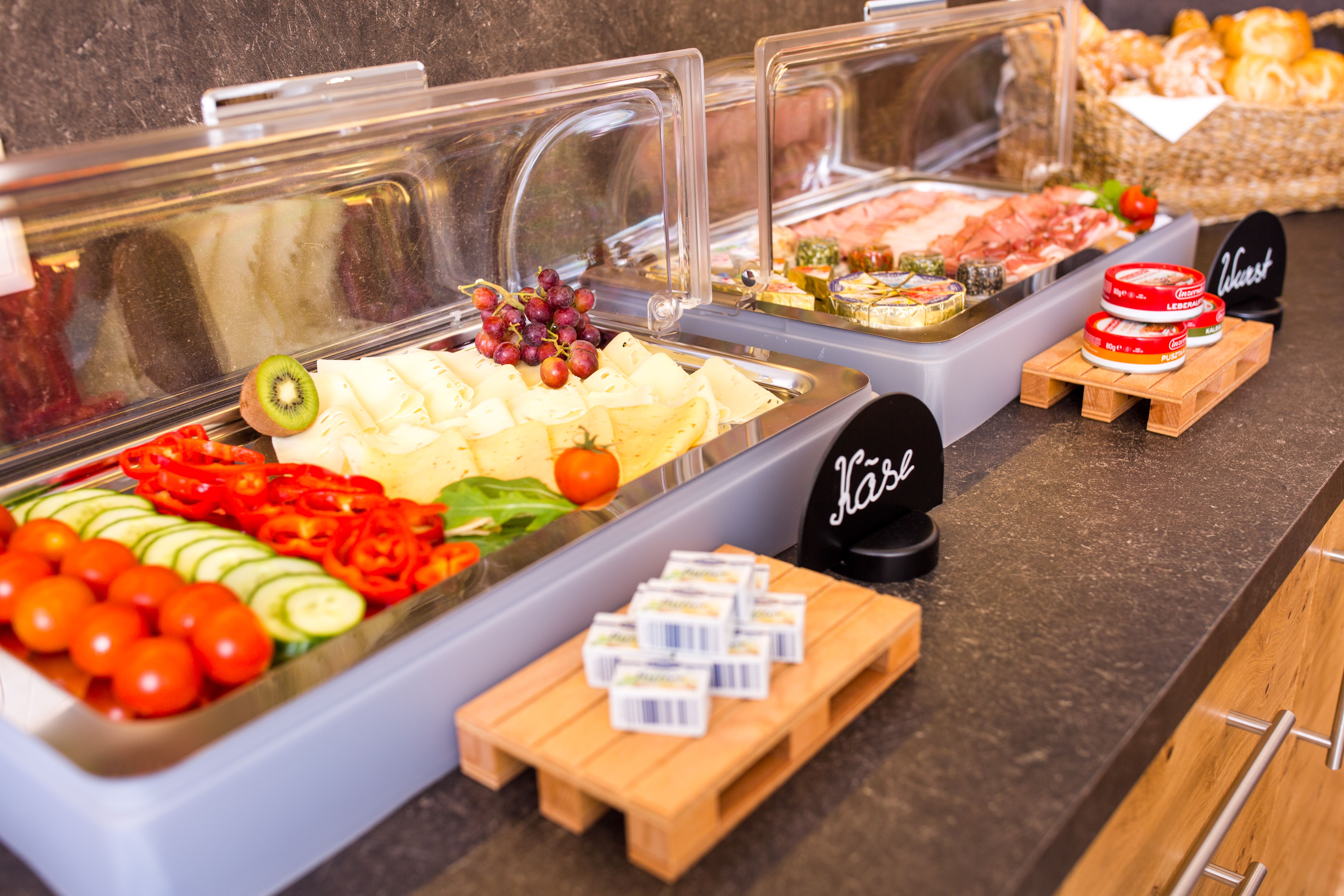 Buffet mit Käse, Aufschnitt, Gemüse und Brot.