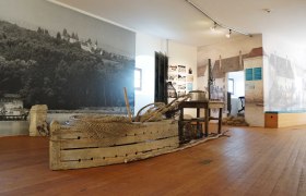 Innenansicht eines Museums mit historischen Fischereiger&auml;ten und Wandbildern.