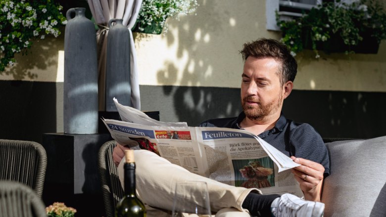 Gastgarten im Weingut & Gästezimmer Edelmann, Mann beim Zeitung lesen