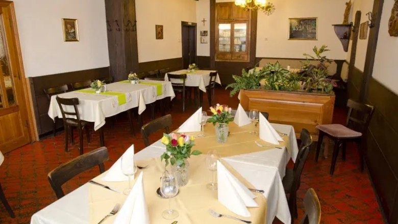 Innenansicht eines traditionellen Restaurants mit gedeckten Tischen und Pflanzen.