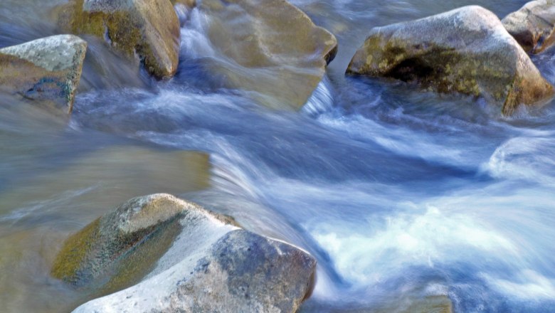 Flie&szlig;endes Wasser &uuml;ber Steine in einem Bach.