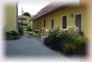 Gelbes Haus mit Garten und gepflastertem Weg.