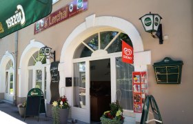 Außenansicht eines Restaurants mit Gösser-Schildern und Eskimo-Eiswerbung.