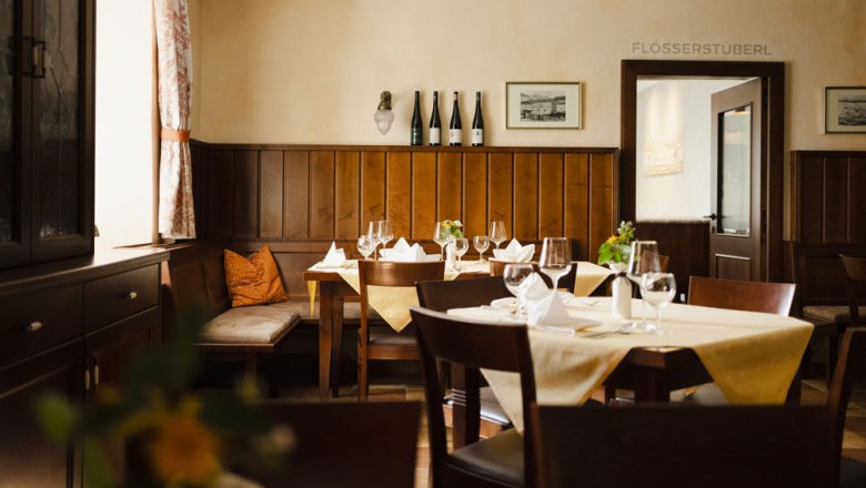 Gem&uuml;tliches Restaurant mit Holzm&ouml;beln und gedeckten Tischen.