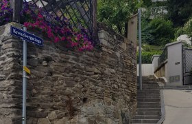 Steintreppe mit Blumen und Straßenschild 'Kreuzbergstiege' in Krems.
