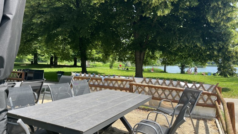 Gartentisch mit Gartenst&uuml;hlen, im Hintergrund das Tullner-Aubad.