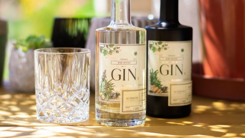 Zwei Ginflaschen und ein Glas auf einem Tisch im Freien.