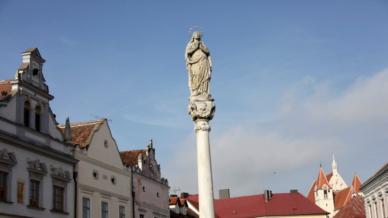 Statue auf einer S&auml;ule in Eggenburg mit historischen Geb&auml;uden im Hintergrund.