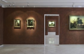 Innenansicht eines Museums mit Gem&auml;lden an braunen W&auml;nden.