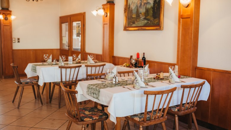 Gem&uuml;tliches Restaurant mit gedeckten Tischen und rustikaler Einrichtung.