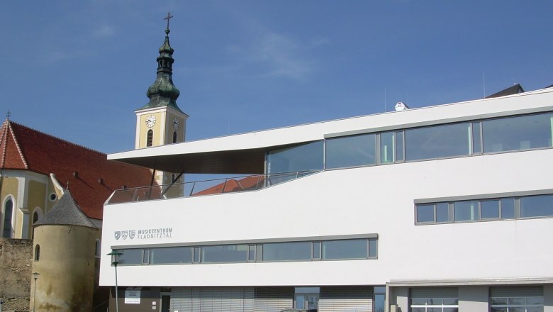 Moderne Geb&auml;ude mit Kirchturm im Hintergrund in W&ouml;lbling.
