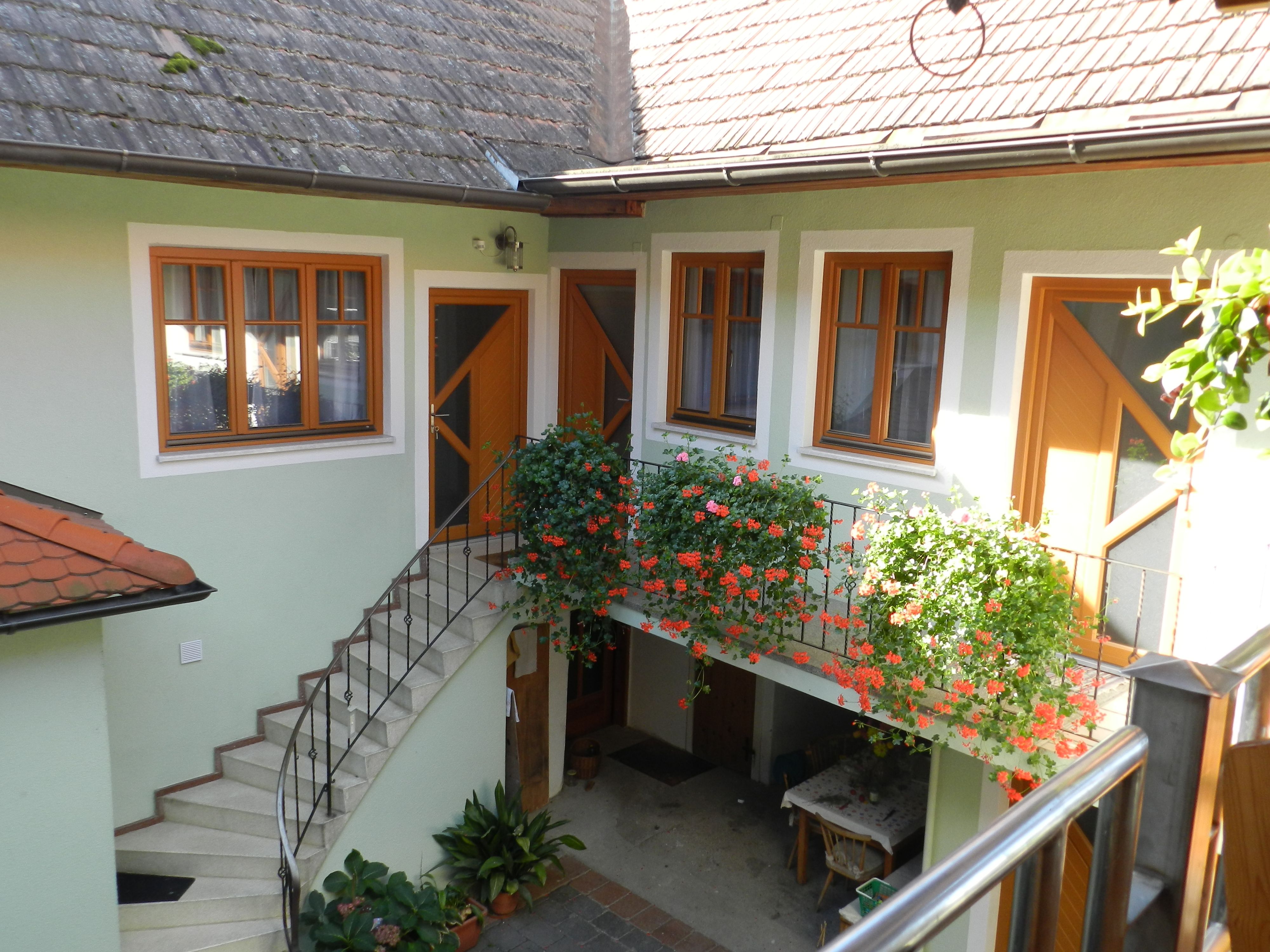 Innenhof mit Treppe, Blumen und Tisch.