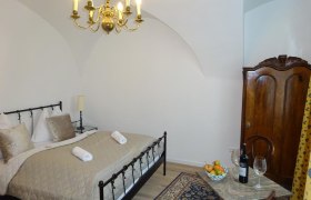 Zimmer mit Doppelbett und Kronleuchter, geschmackvoll Dekoriert