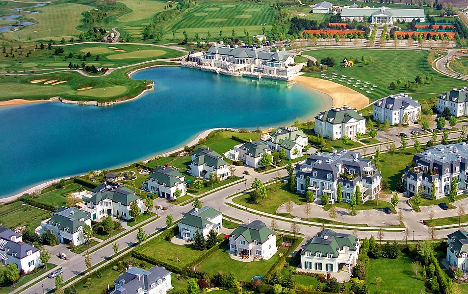 Luftaufnahme von Oberwaltersdorf mit einem See, umgeben von Villen und einem Golfplatz.