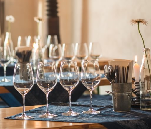 Tisch mit Weingl&auml;sern und Kerzen in einem gem&uuml;tlichen Raum.