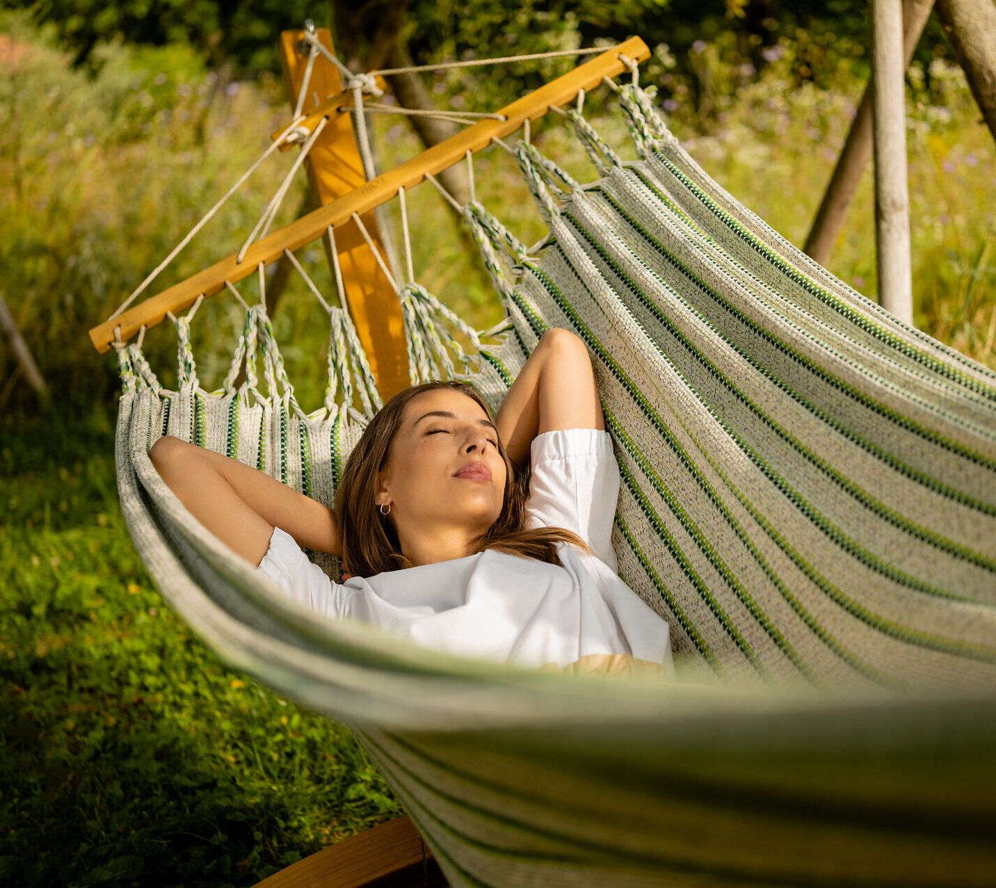 Inmitten der blühenden Wiesen und unter dem sanften Licht der Sonne lädt eine Hängematte zum Entspannen ein. Die sanften Geräusche der Natur und der Duft von frischem Gras schaffen eine harmonische Atmosphäre, die den Sommer in vollen Zügen genießen lässt.