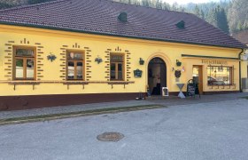 Gelbes Gebäude mit der Aufschrift 'Fleischhauerei' und einem Eingang.