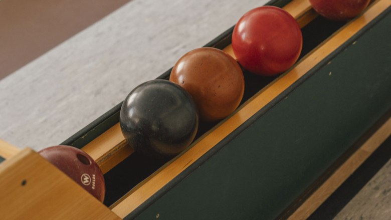 Kegelbahn mit vier Kegelkugeln in einer Halterung.