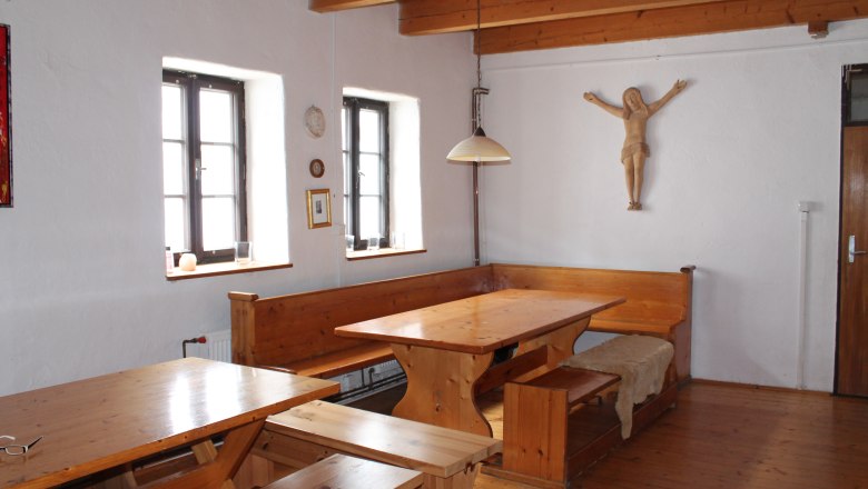 Haus Agnes 1, © Hannes Messmann Rustikaler Raum mit Holzmöbeln, Holzbalkendecke und Wanddekoration.