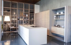 Moderne Küche mit weißer Insel, Regalen und Holzverkleidung.