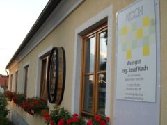 Au&szlig;enansicht eines Weinguts mit Blumen und Schild.