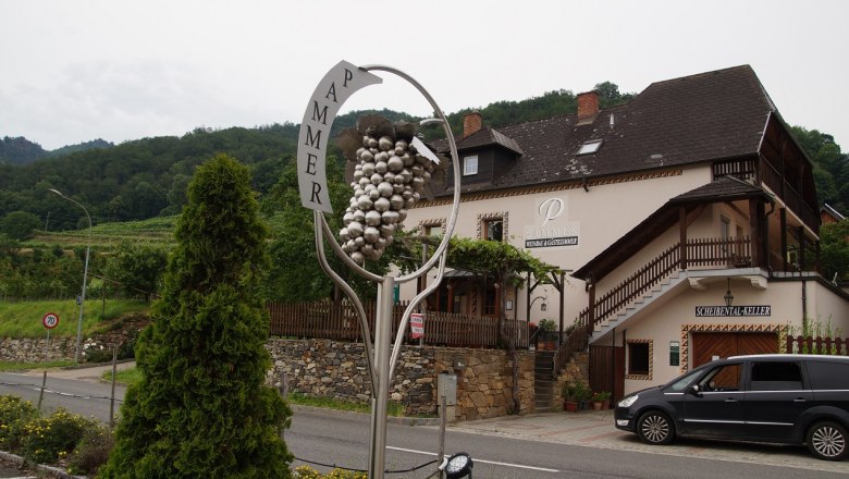 Weingut Pammer mit Traubenskulptur und Geb&auml;ude im Hintergrund.