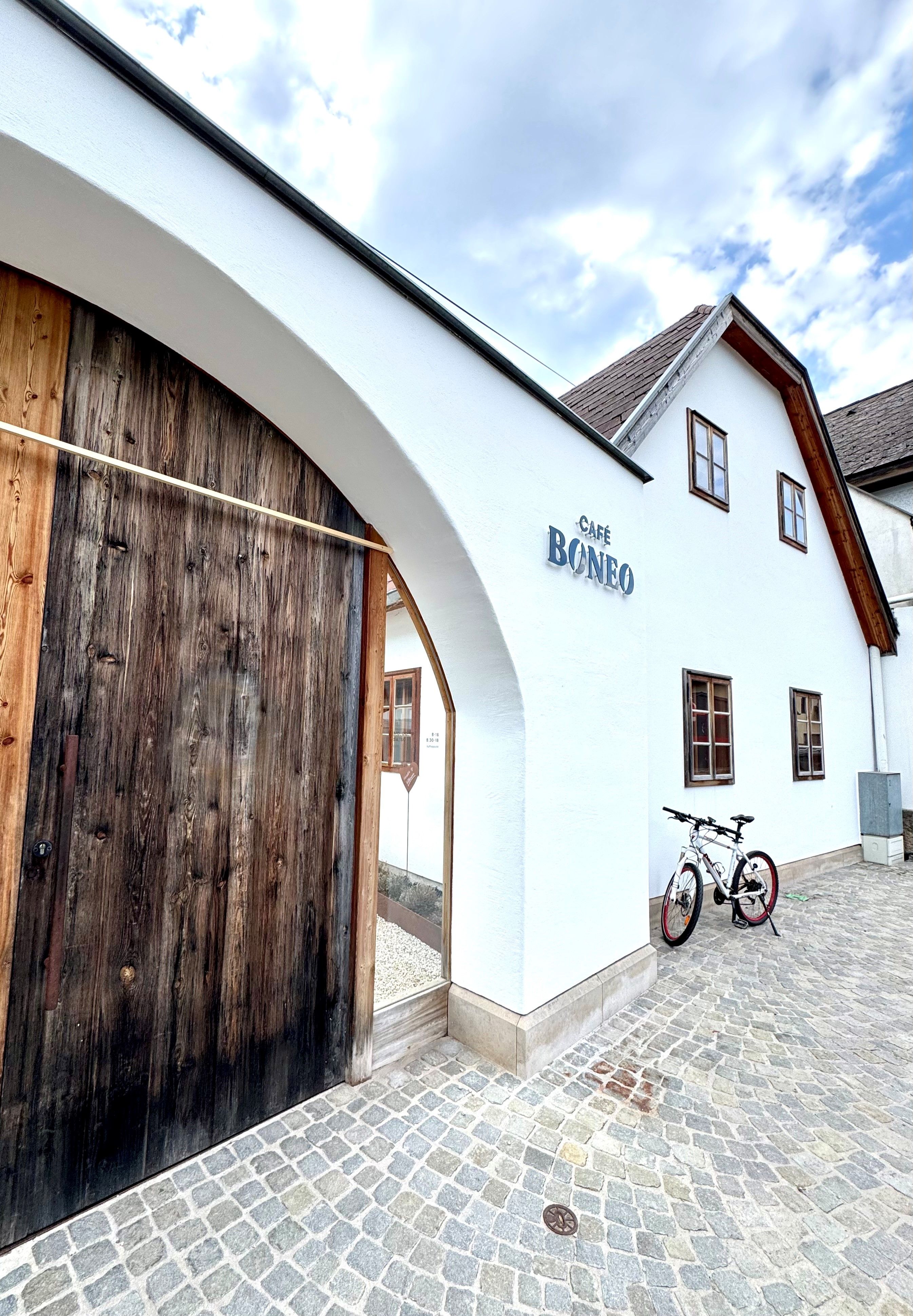 Eingang des Café Boneo in Pernitz mit einem Fahrrad davor.