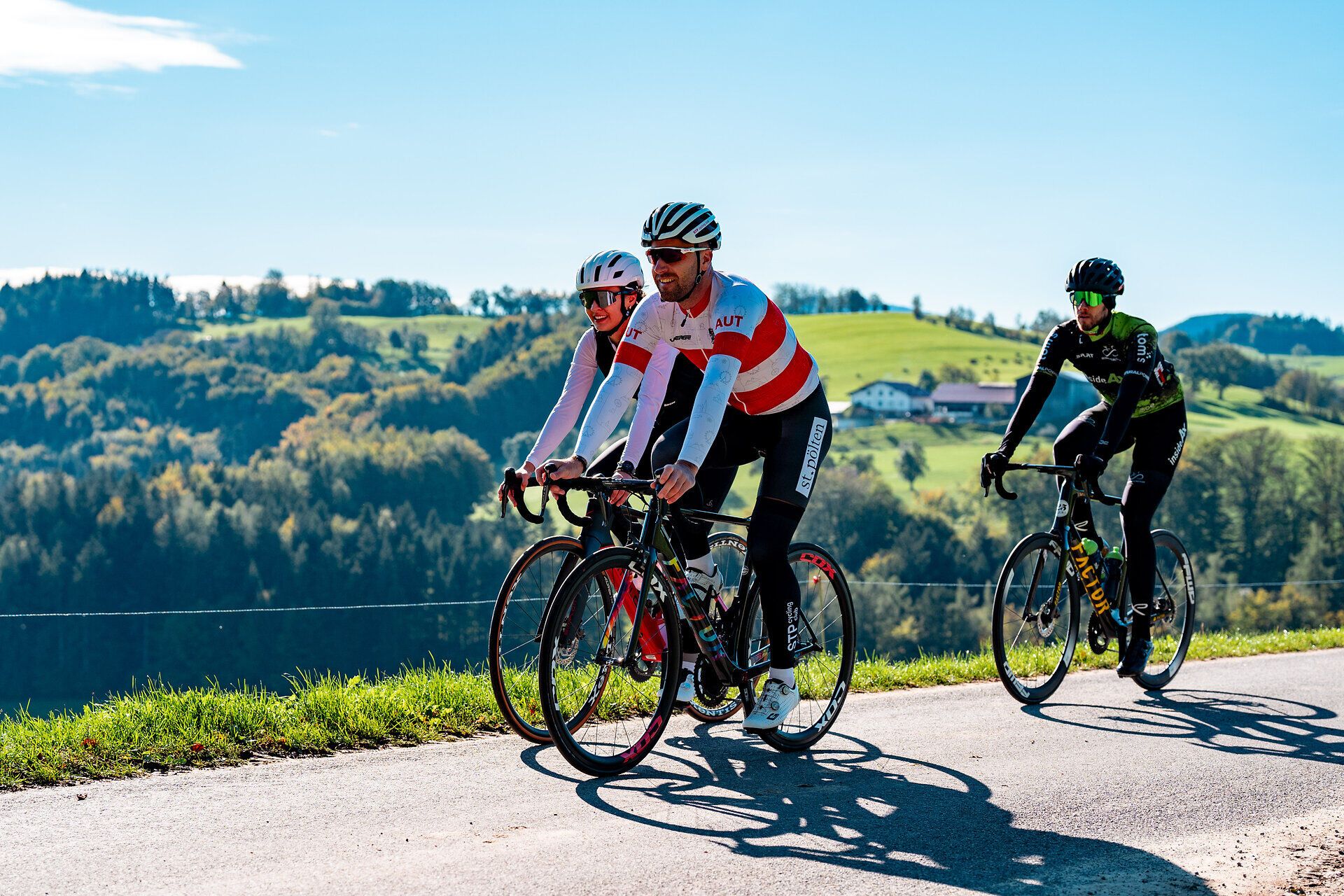 Die Sonne strahlt über die sanften Hügel, während Radfahrer in voller Fahrt die malerische Landschaft genießen. Die frische Sommerluft und die atemberaubenden Ausblicke laden dazu ein, die Schönheit der Natur zu erleben und aktiv zu sein.