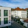 Au&szlig;enansicht des arte Hotels in Krems mit umliegenden Geb&auml;uden und Stra&szlig;e.