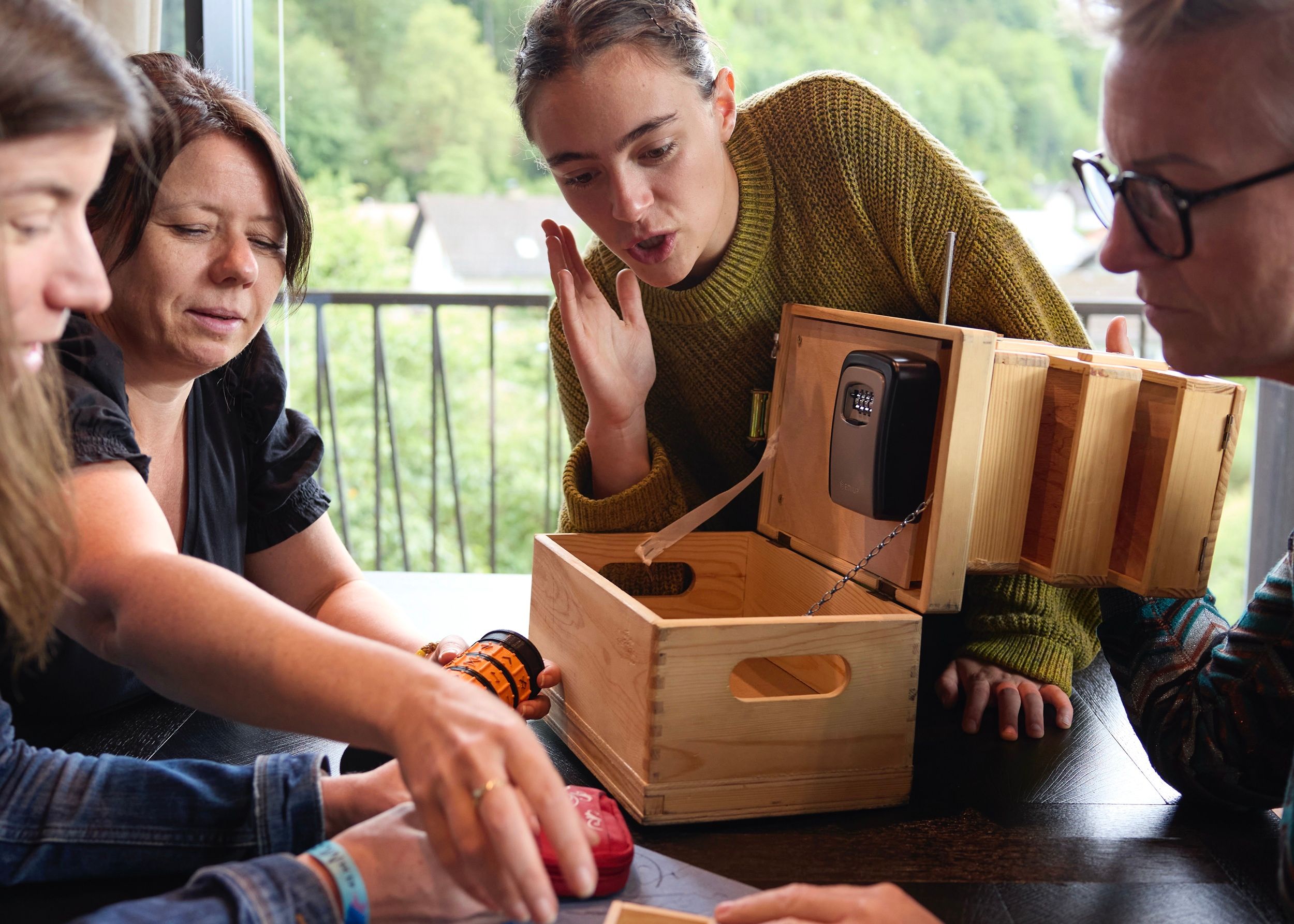 Eine Gruppe bei einem Escape Teamspiel mit einer Holzbox