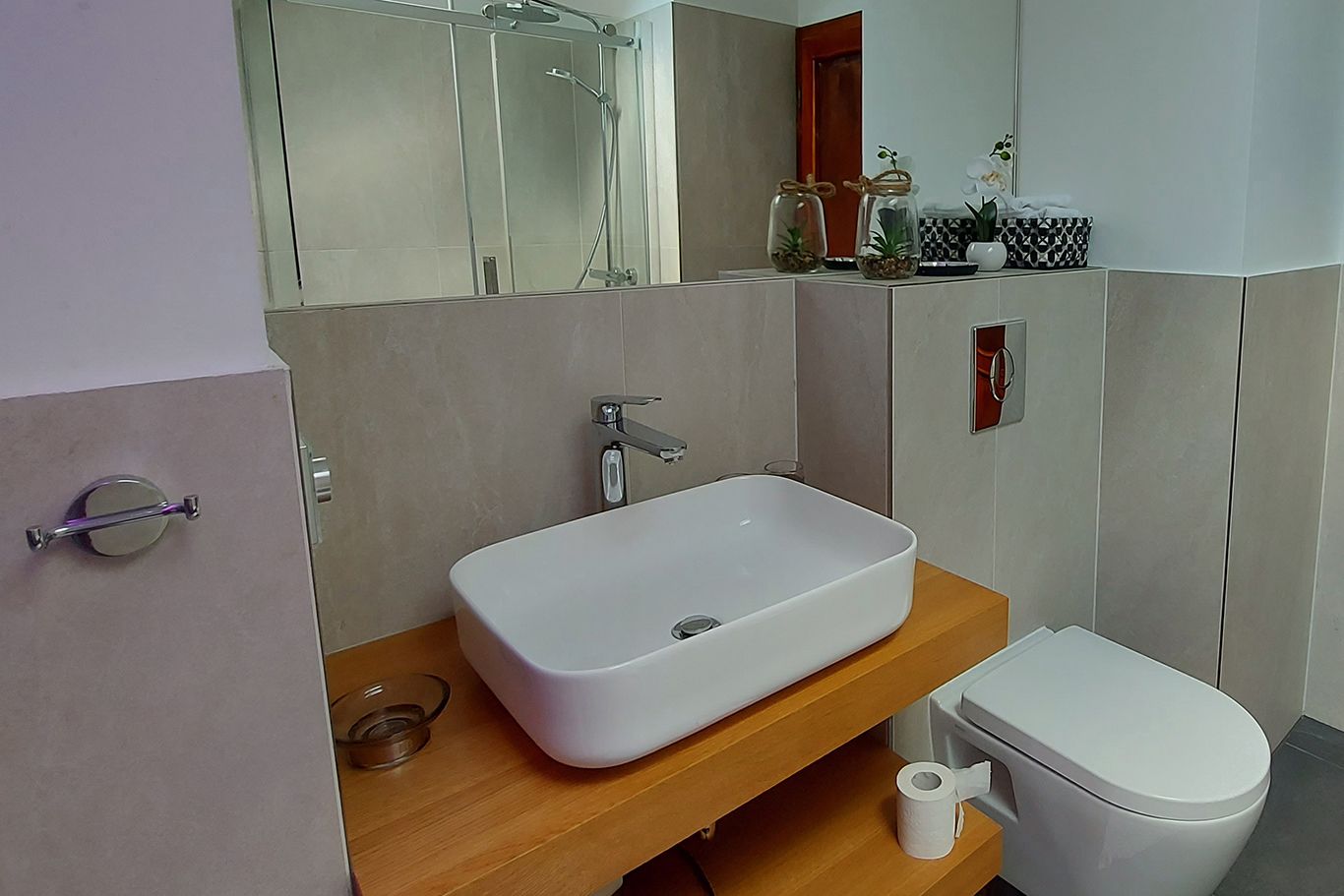 Modernes Badezimmer mit Waschbecken, Toilette und Dusche.